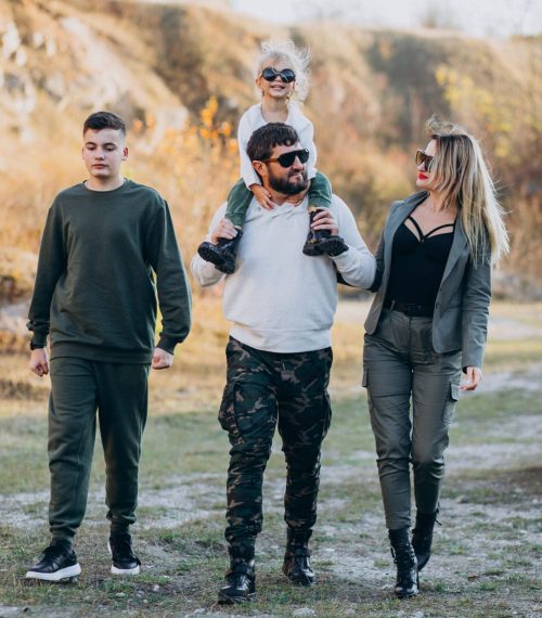Young modern family travelling by car and stopped for a walk in park